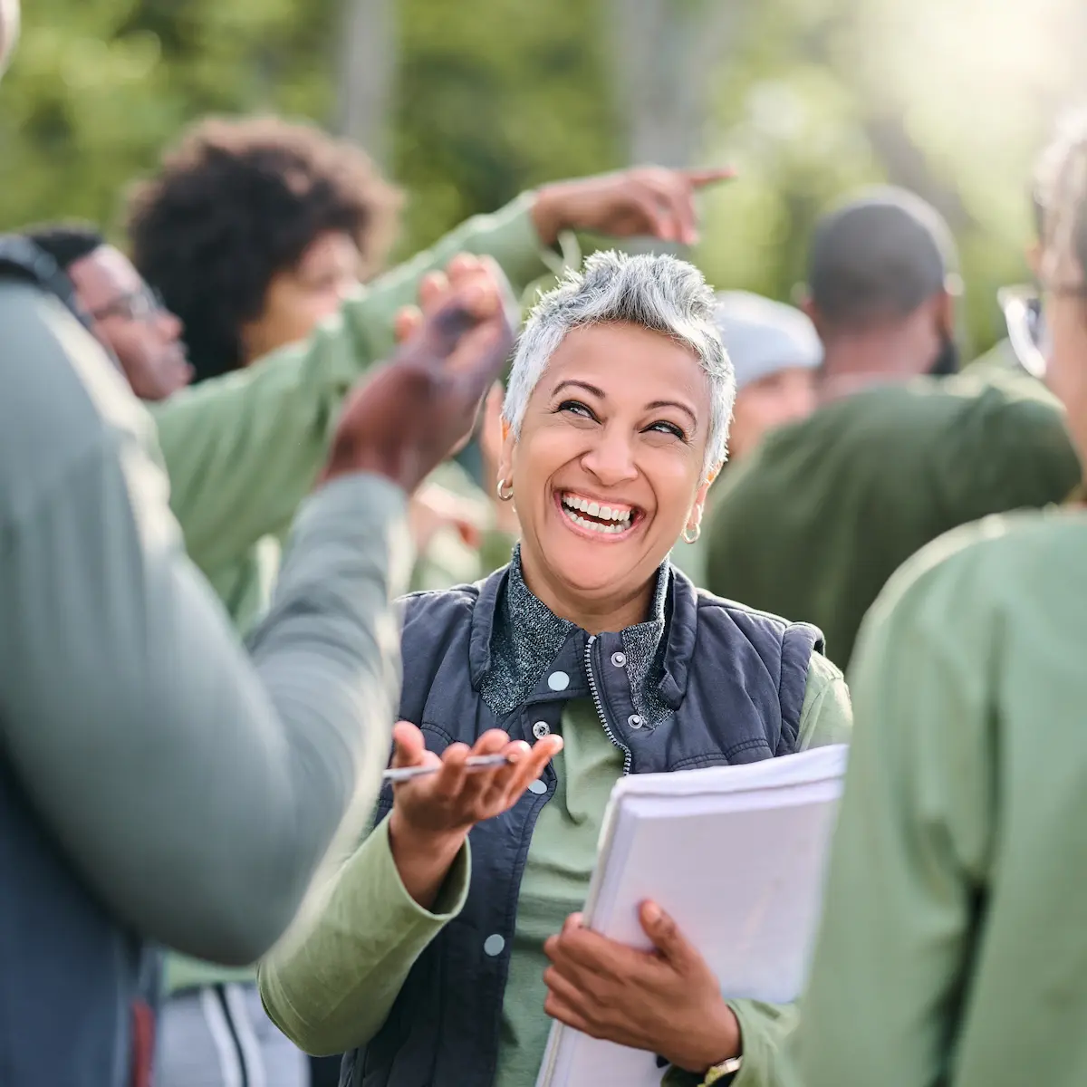 Woman with a note pad speaking to people Woman with a note pad speaking to people
